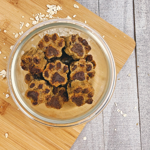 Paw-shaped dog treats in a clear glass bowl.