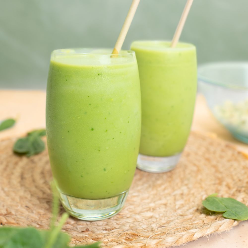 2 glasses of avocado smoothie with straws