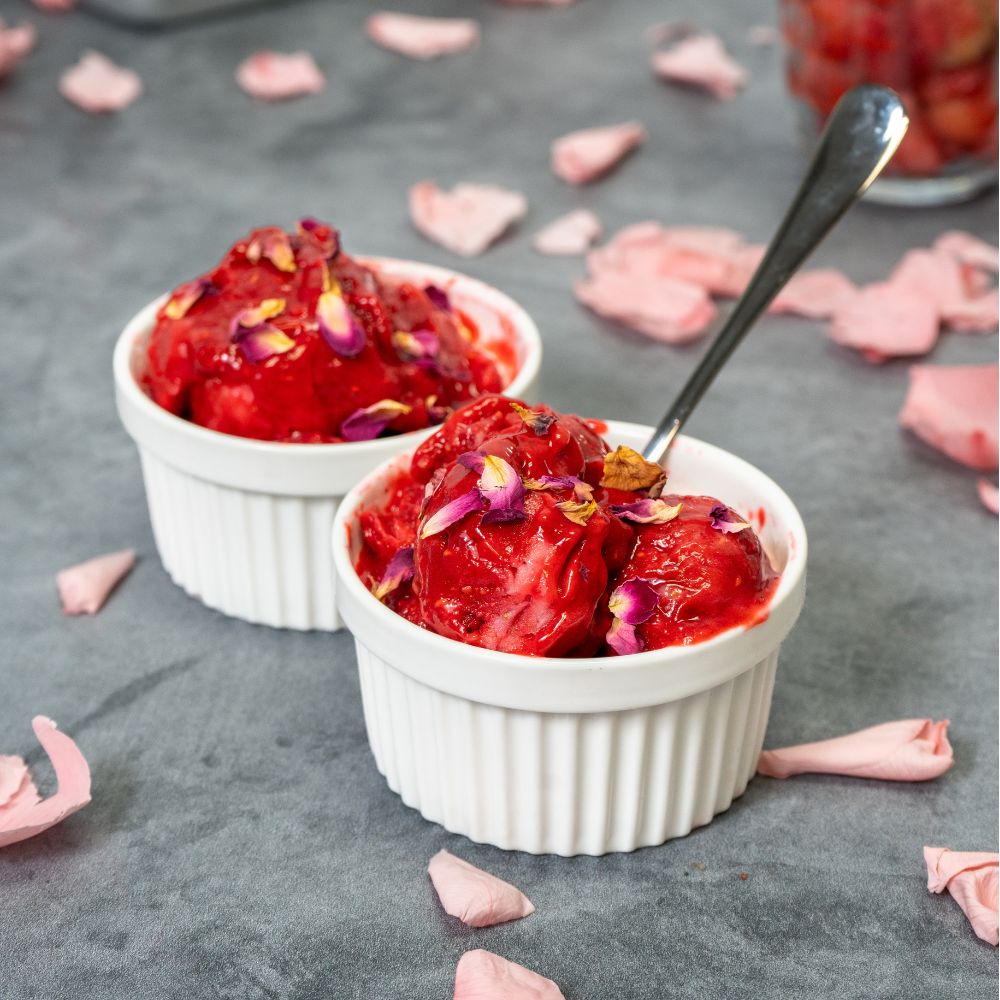 2 bowls of red sorbet with one having a spoon in it